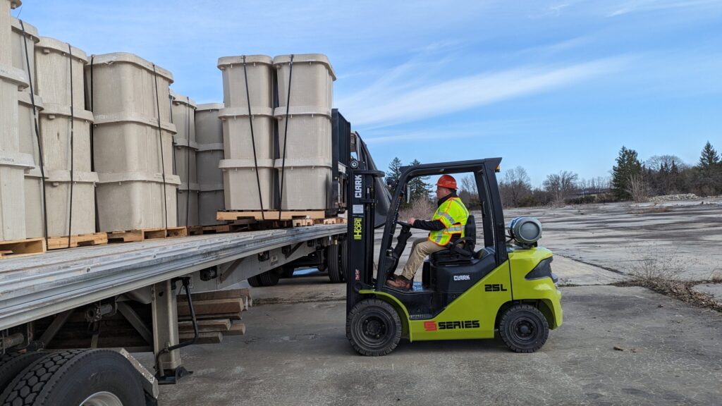 Jim Rhoda, Sr., Outside Plant Project Manager, unloads handholes, underground vaults that allow easy access to wires and cables, at Archtop Fiber’s storage area.